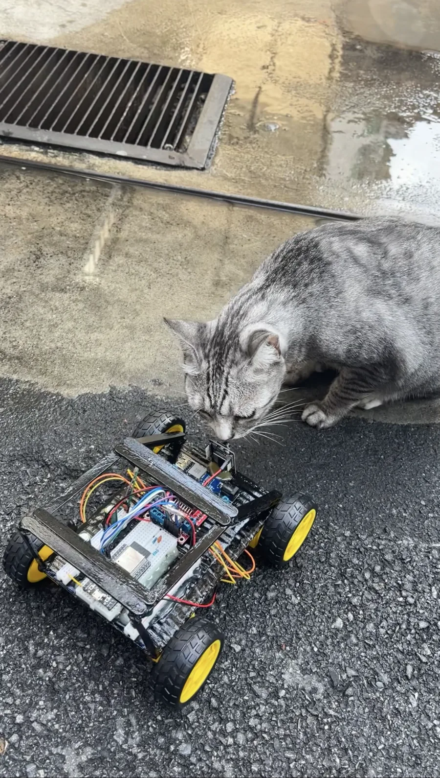 Wi-Fi controlled RC car on a floor beside workshop materials